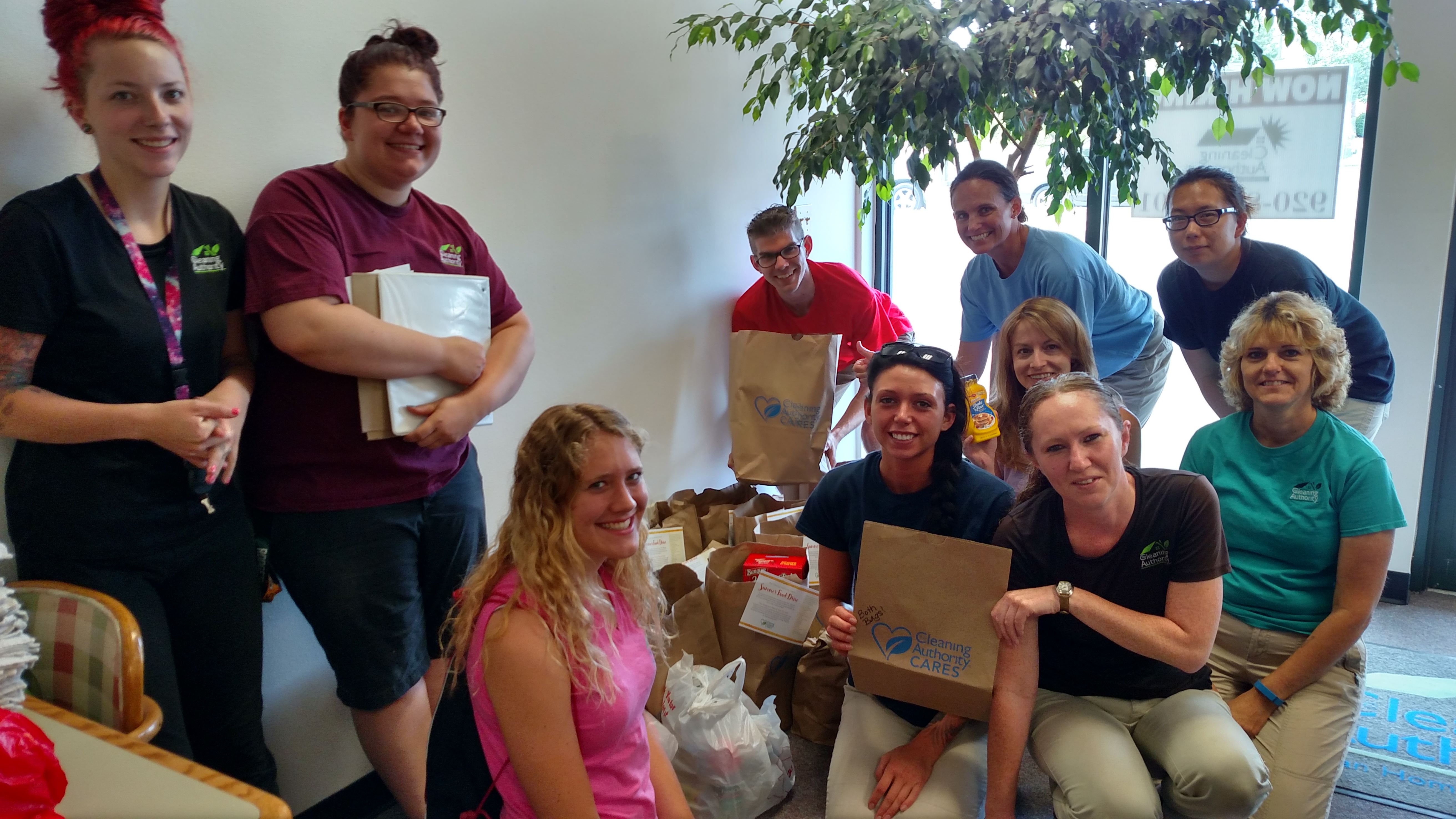 The TCA Appleton team poses with food donations collected for a local food bank.