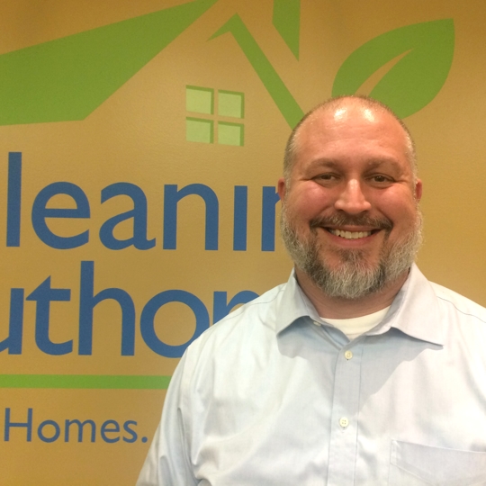 Guy smiling in front of wall