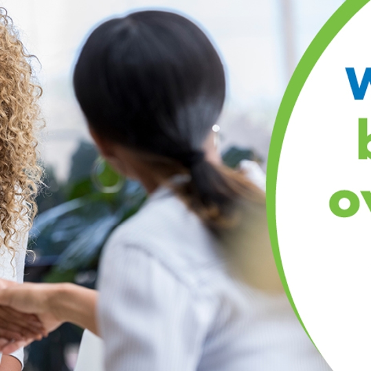 A women sitting smiling shaking hands