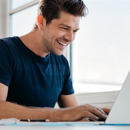 Man smiling at computer