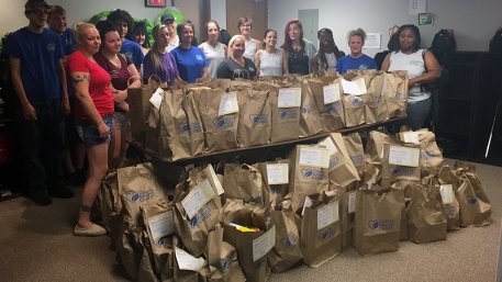 The TCA Clinton Township team poses with the food donations collected for local charities.