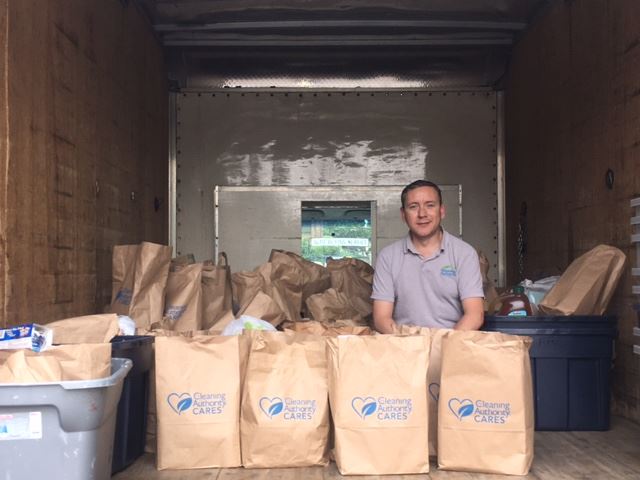 A member of the TCA Fairfax team sits in a box truck with bags full of donations the team collected.