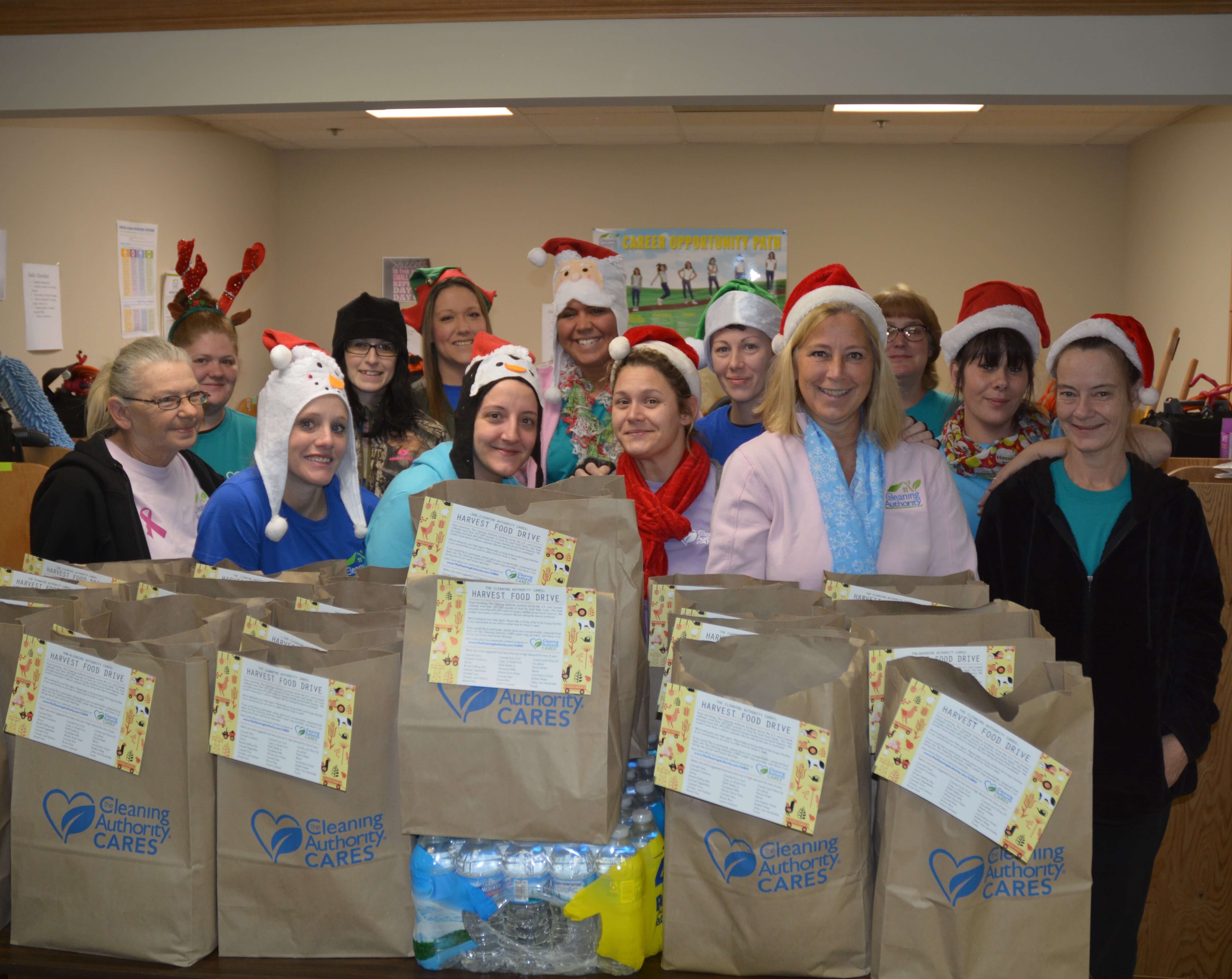 The TCA North Kentucky team stands in their office with donations collected for a local charity.