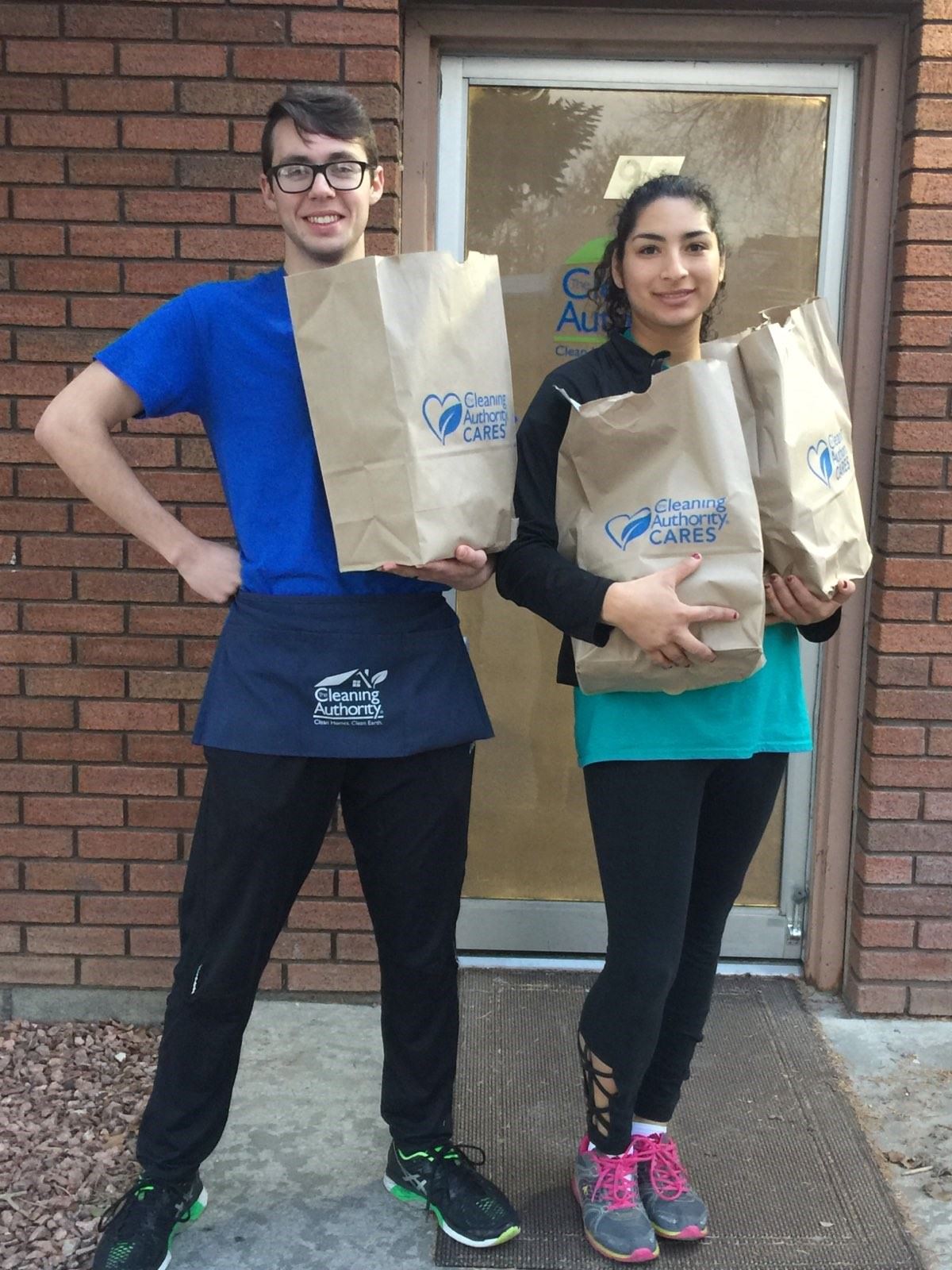 Two members of the TCA Provo team pose with donations collected for a local charity.