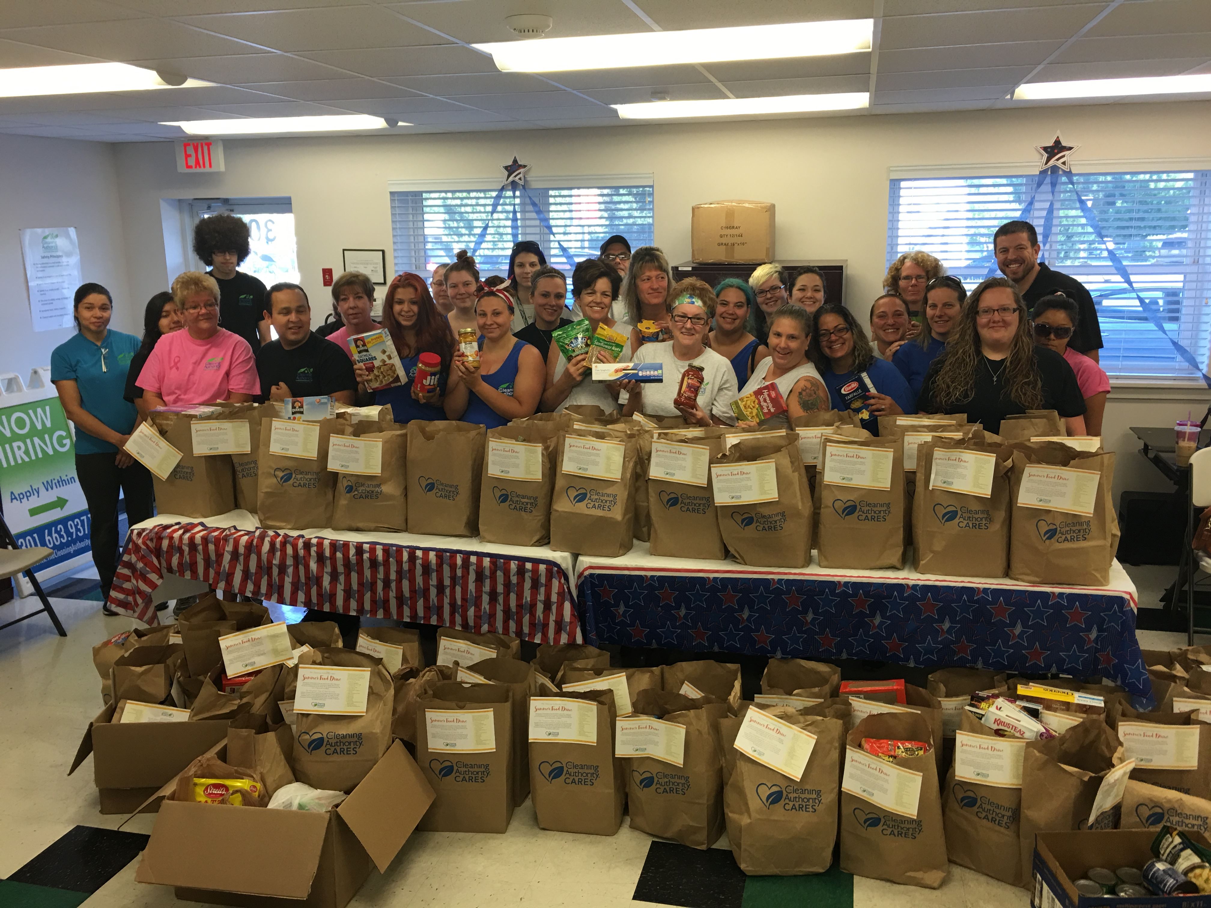 The TCA Frederick team poses with the food donations collected for local charities.