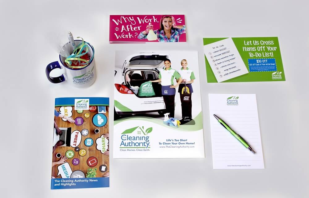 Marketing materials including a brochure, postcard, leave-behind, mug, notepad, and pen.